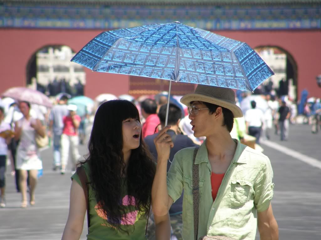 打傘的年輕人。現在，單憑衣著，北京街頭已經很難說清楚著裝者的國籍了。